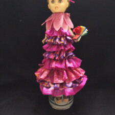 ALYCE MCDONALD
Her name is "Lilly", body made from the empty yarn cone painted pink, she has a little slip on for modesty, all the ruffles are made from Sari silks, she has a gold sprayed shabby chic tiara in her hair made from the t-lite tin. The pink twist ties were sprayed gold and are her ankle bracelets.
The flower collar adorns her neck and she carries a folded prayer flag that she is delivering.
The green hair bow was not used.